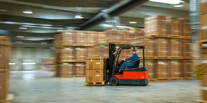 Forklift moving boxed product through a cold storage warehouse